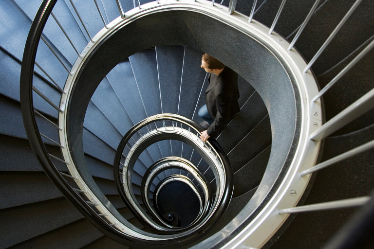 business man walking spiral staircase