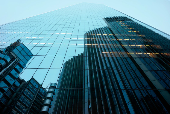 Tall buildings reflected on the side of a glass skyscraper