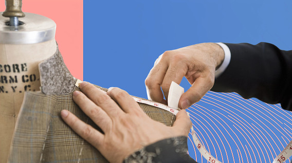 The image features a close-up of a tailor measuring a suit on a dress form. A hand, wearing a formal black suit, is seen adjusting a measuring tape around the shoulder area of the garment.